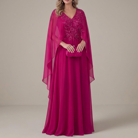 Vestido Liora fucsia con capa, vista frontal sobre fondo gris cálido