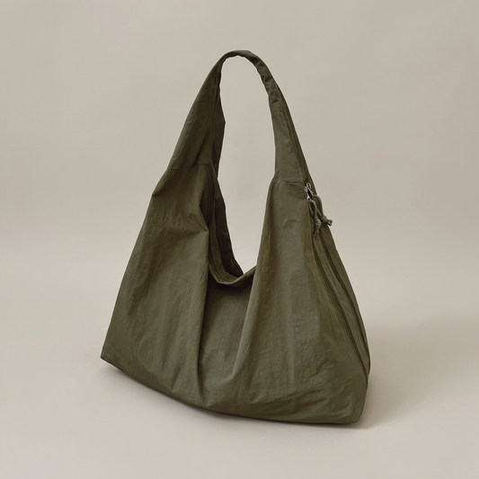 Bolso tote verde principal con fondo gris cálido